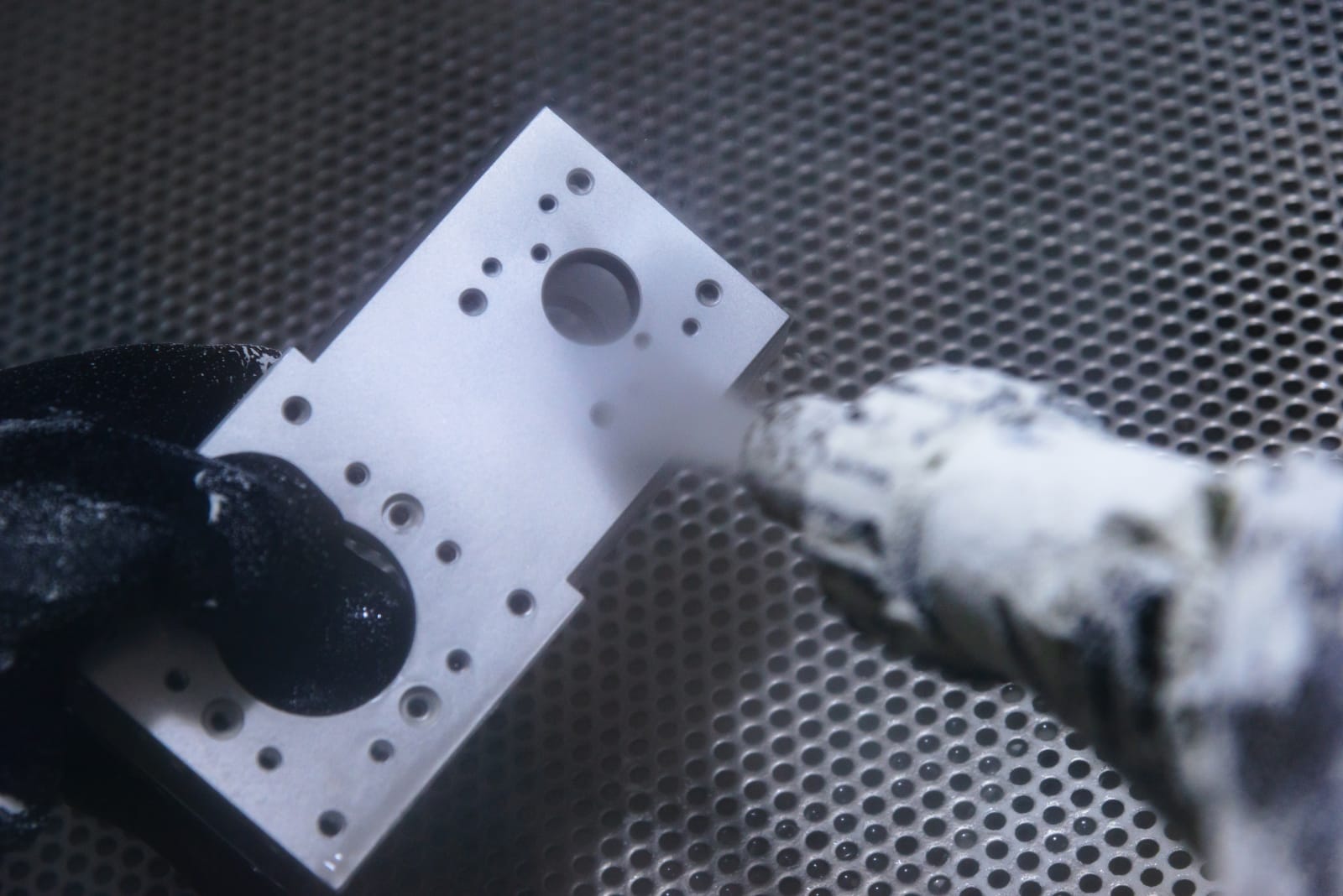 Sandblasting and vibratory finishing of parts